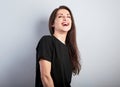 Happy laughing beautiful woman  on blue background and happy looking up in black t-shirt. Portrait Royalty Free Stock Photo