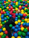 Happy laughing boy having fun in ball pit on birthday party in kids amusement park and indoor play center Royalty Free Stock Photo