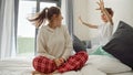 Happy laughing boy scare and plays with mother wearing pajamas on bed. Concept of happy family, parents with kids, positive Royalty Free Stock Photo