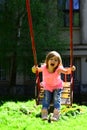 Happy laughing child girl on swing. childhood daydream .teen freedom. Playground in park. Small kid playing in summer Royalty Free Stock Photo