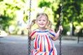 Happy laughing child girl on swing.