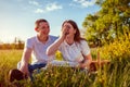 Happy laughing couple eating pizza outside. Woman and man having picnic at sunset. Guys hanging out together