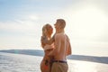 Happy laughing couple in love laughing at the beach against sun