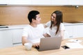 Happy laughing couple is together using laptop and looking at each other at home Royalty Free Stock Photo