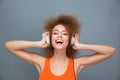 Happy laughing curly girl listening to music using headphones