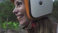 Happy laughing female motor biker wearing helmet sitting on bike at the street.