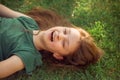 Happy laughing fun kid girl lying on the grass on nature summer background. Closeup positive outdoors bright sunny Royalty Free Stock Photo