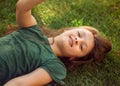 Happy laughing fun kid girl lying on the grass on nature summer background. Closeup positive outdoors bright sunny Royalty Free Stock Photo