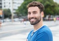 Happy laughing guy with beard and blue shirt in city Royalty Free Stock Photo