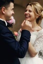 Happy laughing handsome groom and gorgeous emotional bride in white dress close-up