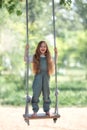 Happy laughing kid girl with long hair enjoying a swing ride on a sunny summer day Royalty Free Stock Photo