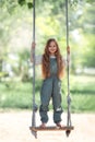 Happy laughing kid girl with long hair enjoying a swing ride on a sunny summer day Royalty Free Stock Photo