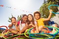 Happy laughing kids sit with hula rings in garden Royalty Free Stock Photo