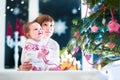 Happy laughing kids under a beautiful Christmas tree in a dark living room Royalty Free Stock Photo