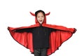 Happy laughing little Asian child girl dressed Halloween costume. Kid in Dracula robe on white background