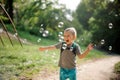 Happy laughing little boy with soap bubbles in summer park on sunny day Royalty Free Stock Photo