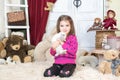 Happy laughing little girl playing with a baby rabbit, hugging her real bunny pet and learning to take care of an animal Royalty Free Stock Photo