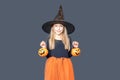A happy laughing little girl in a witch costume and makeup holds pumpkin baskets for Halloween treats Royalty Free Stock Photo
