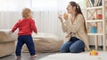 Happy laughing mother cheering while her baby son making first steps on floor at home. Baby development, family playing games, Royalty Free Stock Photo