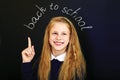 Happy laughing school child near school blackboard