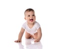 Happy laughing screaming toddler baby in diaper and white bodysuit is crawling on all fours looking at upper corner Royalty Free Stock Photo