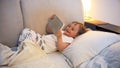 Portrait of happy laughing toddler boy lying in bed with digital tablet Royalty Free Stock Photo