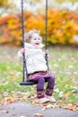 Happy laughing toddler girl playing on swing