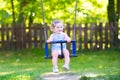 Happy laughing toddler girl swinging ride on playground Royalty Free Stock Photo