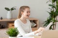 Happy laughing woman sitting at the desk reading documents