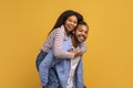Happy laughing young black couple having fun against yellow studio background Royalty Free Stock Photo