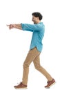happy lebanese man pointing fingers to side, smiling and walking Royalty Free Stock Photo