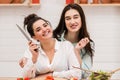 Happy lesbian couple preparing food in kitchen. Royalty Free Stock Photo
