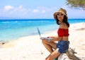 Happy lifestyle with work vacation with young asian woman freelancer sitng as working on the beach-Summer vacation concept Royalty Free Stock Photo