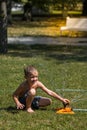Happy little boy playing in water drops from irrigation hose, heat in the city Royalty Free Stock Photo