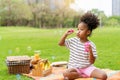 Happy little african american curly hair girl blowing soap bubbles playing alone in the park, Black hair style Royalty Free Stock Photo