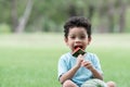 Happy little African American kid boy picnic eating a piece of watermelon and sitting in the park in summer Royalty Free Stock Photo