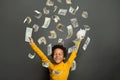 Happy little african american kid boy under us dollar money rain on black background Royalty Free Stock Photo