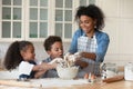 Happy little African children learning cooking with mum. Royalty Free Stock Photo