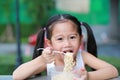 Happy little Asian child girl eating Instant noodles at the garden