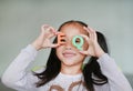 Happy little Asian child girl holding alphabet EQ Emotional Quotient text on her face. Education concept