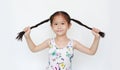 Happy of little Asian child girl holding pigtail on white background. Portrait smiling kid with two pigtails