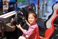 Happy little Asian child girl playing arcade video game. Racing car Royalty Free Stock Photo