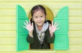 Happy little Asian child girl playing with window toy playhouse in playground Royalty Free Stock Photo