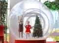 Happy little Asian child girl in santa costume dress playing in big winter Snow globe with reindeer on christmas time. Merry Xmas Royalty Free Stock Photo