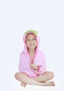 Happy little Asian child girl smiling under towel after bath sitting on white background Royalty Free Stock Photo