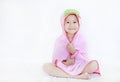 Happy little Asian child girl smiling under towel after bath sitting on white background Royalty Free Stock Photo