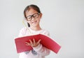 Happy little Asian child girl wearing eyeglasses and hold a book and write with pencil on white background Royalty Free Stock Photo