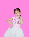 Happy little Asian child girl wearing pink Traditional Chinese dress for Chinese New Year celebration isolated on pink background Royalty Free Stock Photo