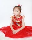 Happy little Asian child girl wearing red cheongsam with greeting gesture celebration for Chinese New Year isolated on white Royalty Free Stock Photo