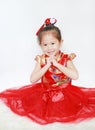 Happy little Asian child girl wearing red cheongsam with greeting gesture celebration for Chinese New Year isolated on white Royalty Free Stock Photo